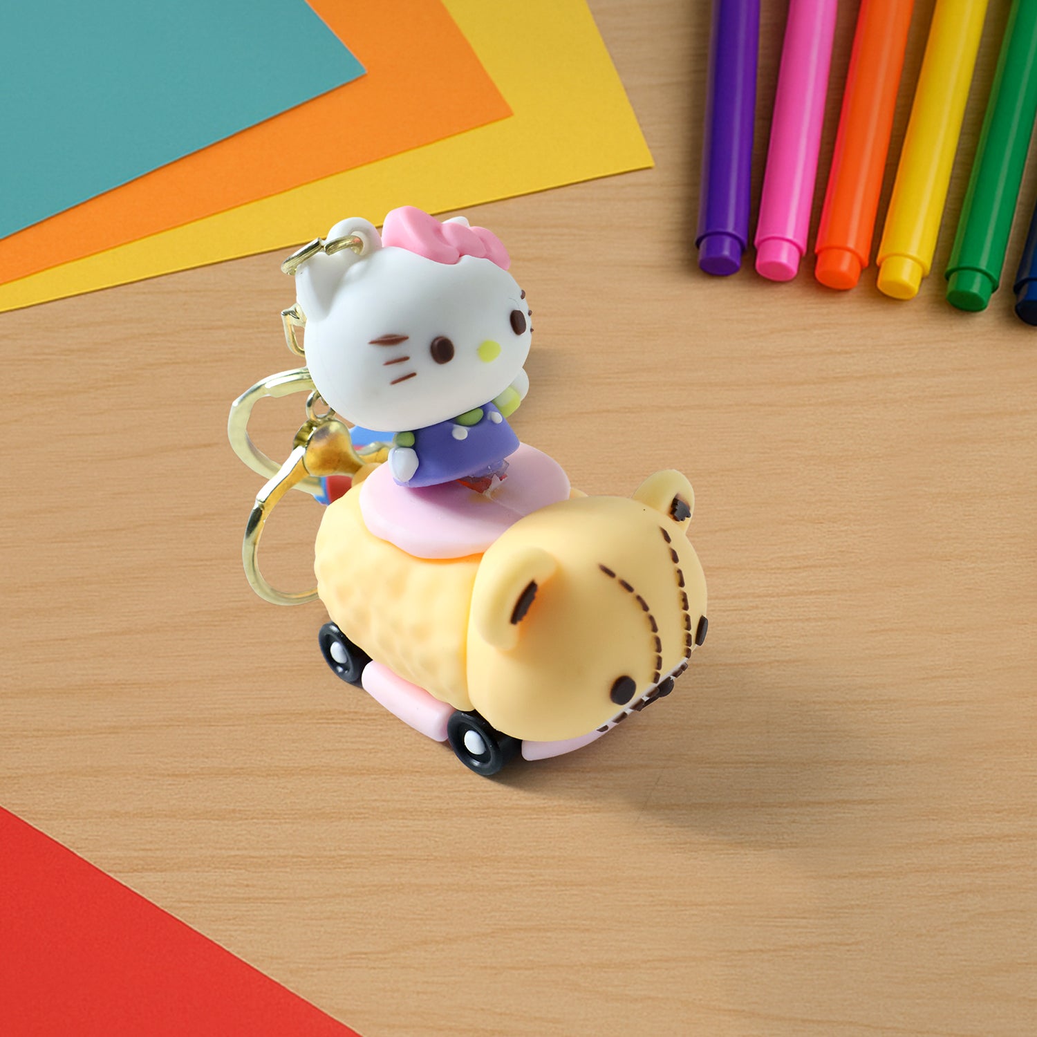 Wukusy cute cartoon cat riding toy car silicone keychain, colorful and playful accessory with detailed cat and car design.