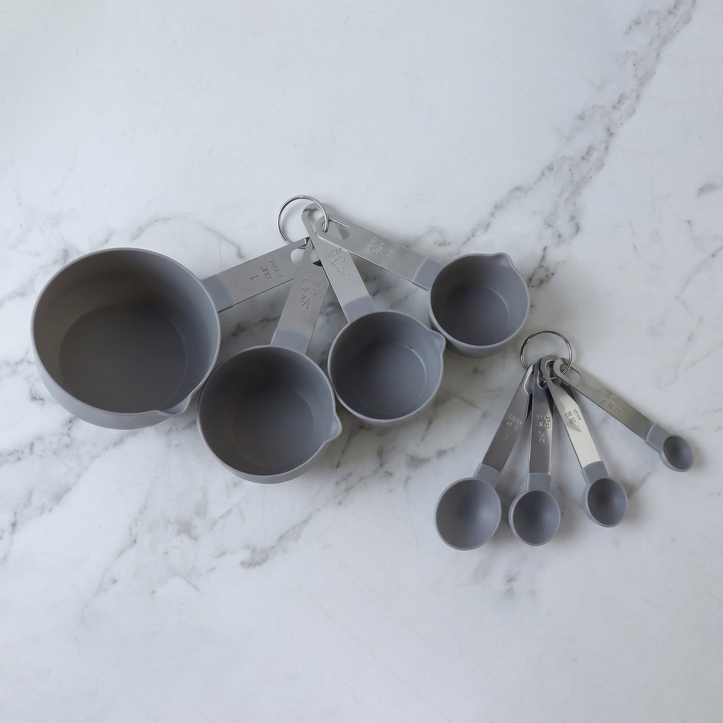 Set of Wukusy plastic measuring cups and spoons for kitchen baking and cooking, displayed together on a neutral background.