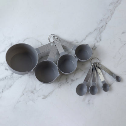 Set of Wukusy plastic measuring cups and spoons for kitchen baking and cooking, displayed together on a neutral background.