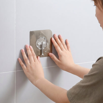 Self-adhesive plastic bathroom wall hook by Wukusy, mounted on the wall for hanging towels or accessories.