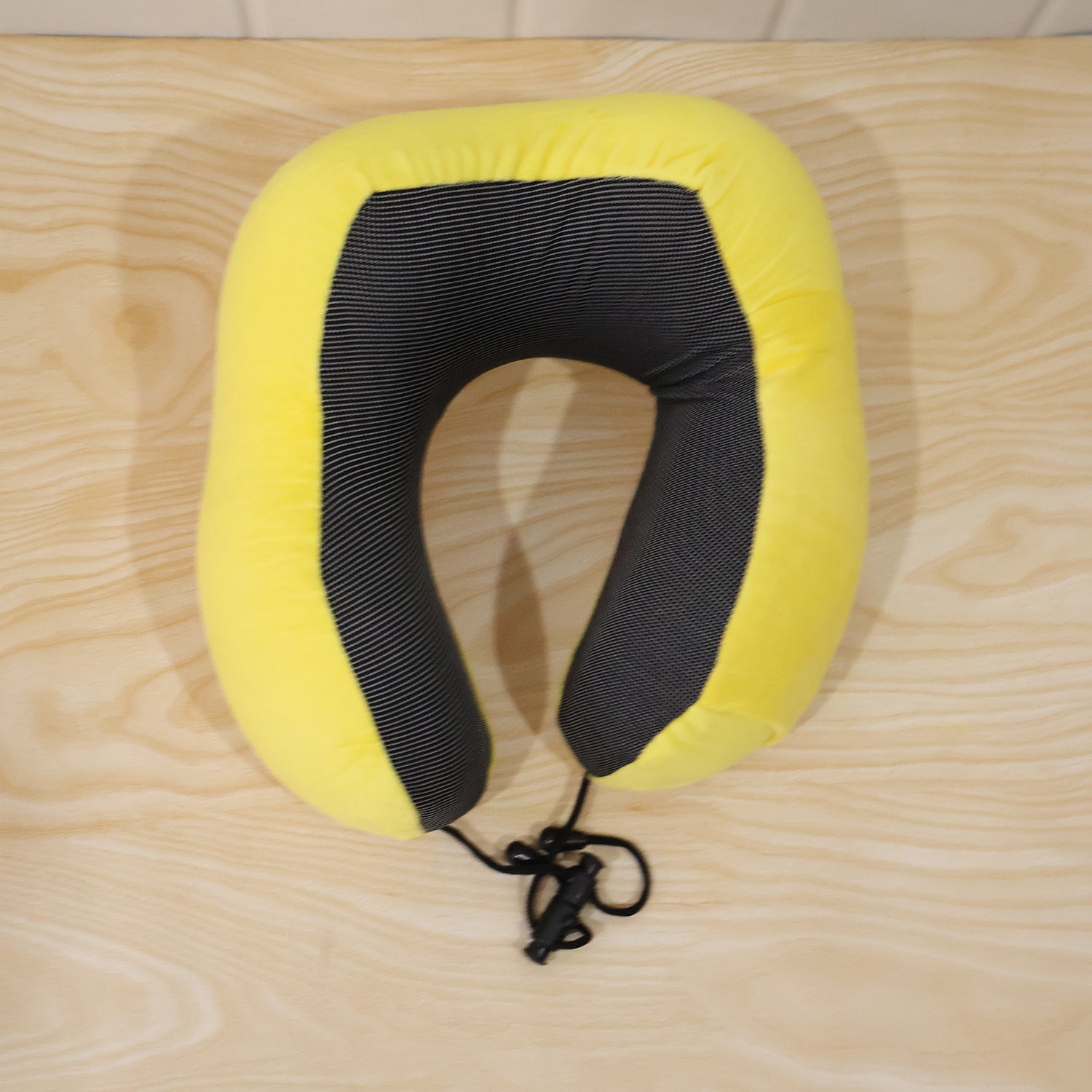 Yellow plush U-shaped neck pillow by Wukusy with drawstring for travel comfort, soft and supportive for neck and head.