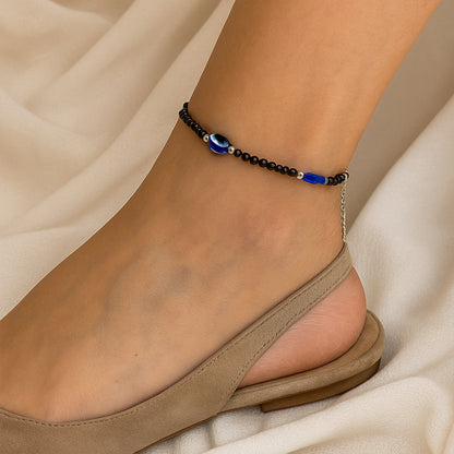 Set of two black beaded evil eye protection bracelets by Wukusy featuring adjustable fit and traditional blue eye charms.