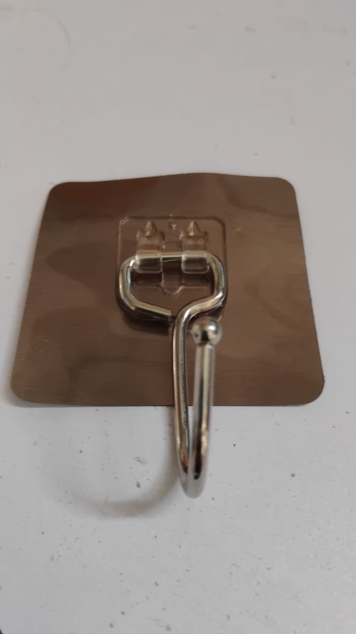 Large stainless steel Wukusy self-adhesive wall hook for home and kitchen, mounted on a wall with a smooth surface.