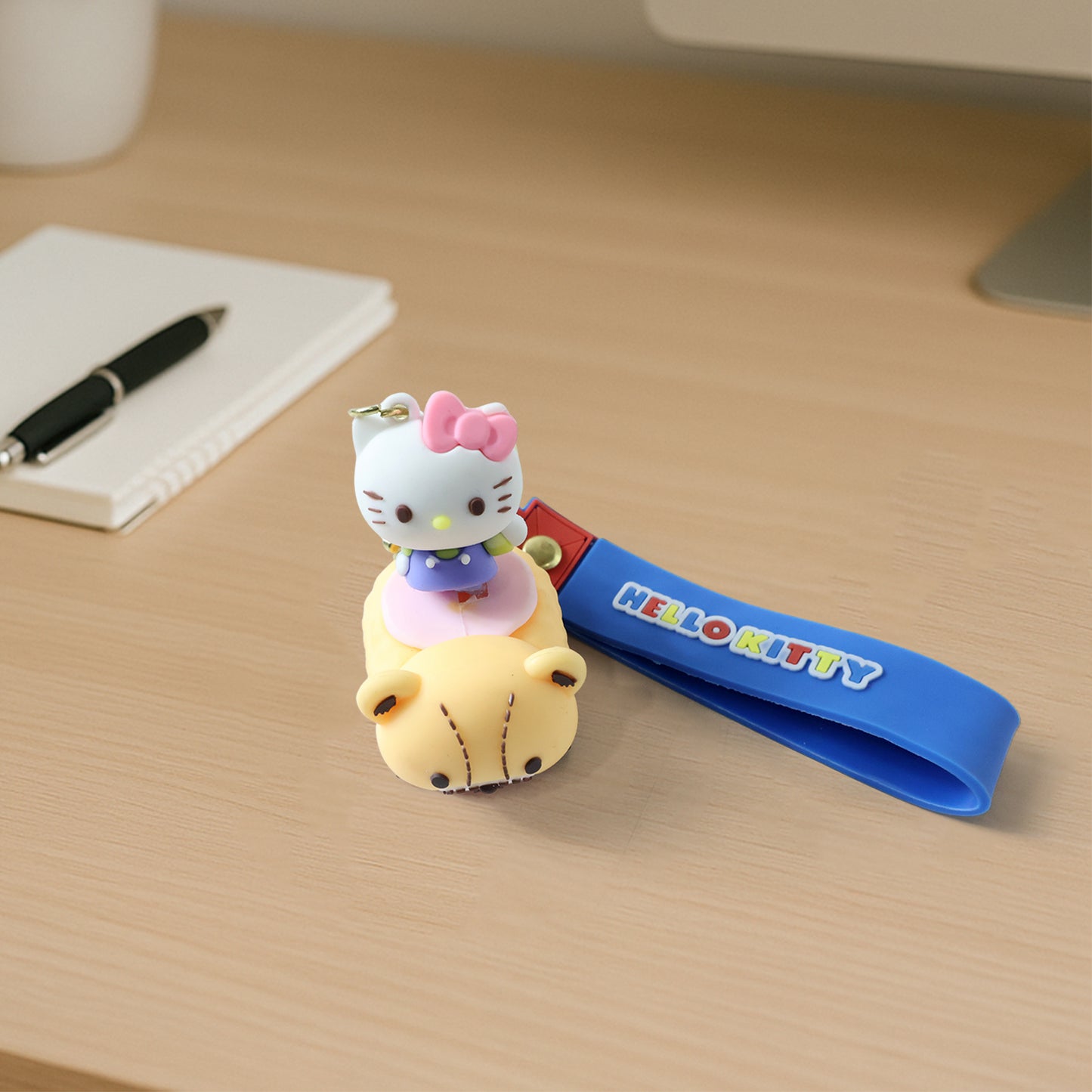 Cute cartoon cat riding toy car silicone keychain, Wukusy brand, featuring a colorful cat figure on a small vehicle.