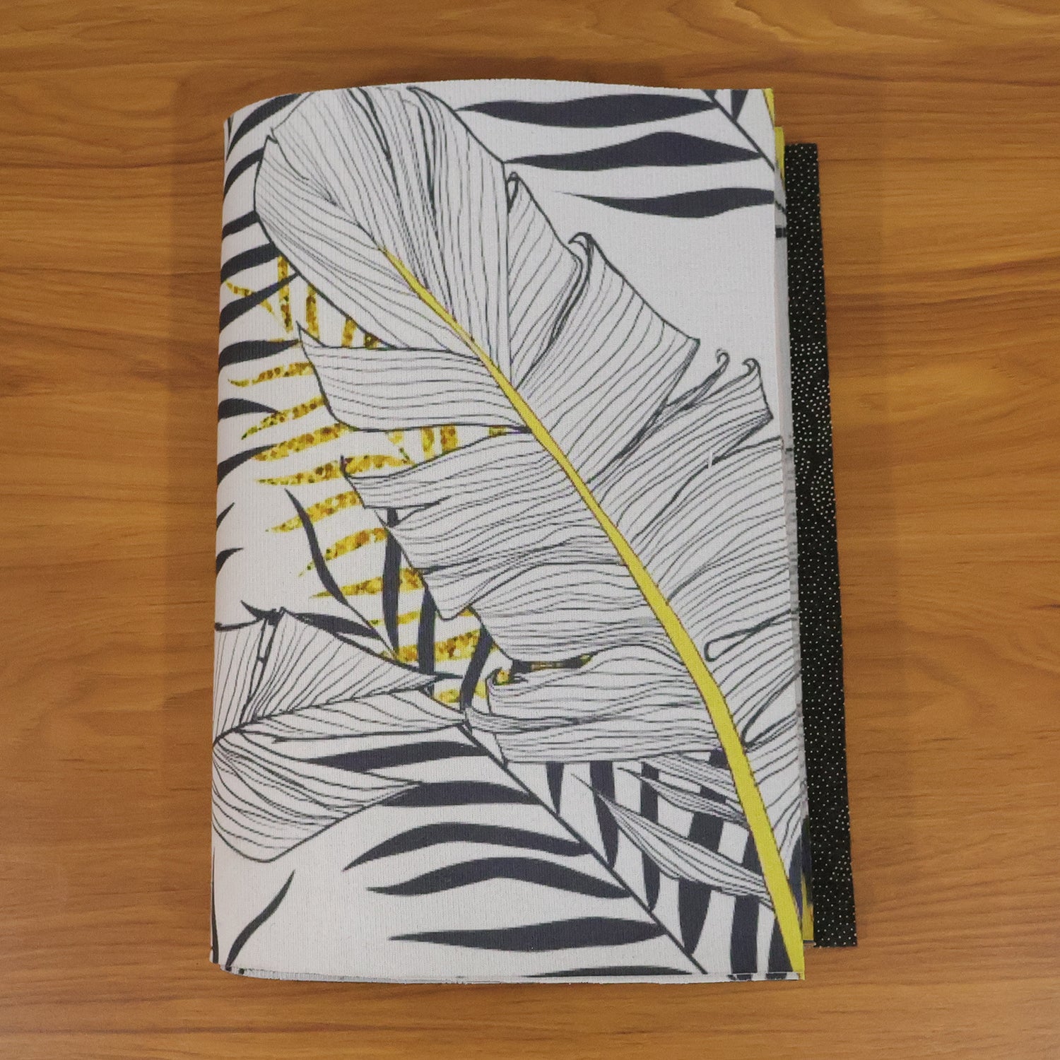 Two reversible Wukusy dining table placemats in small and large sizes, showing both sides with colorful patterns.