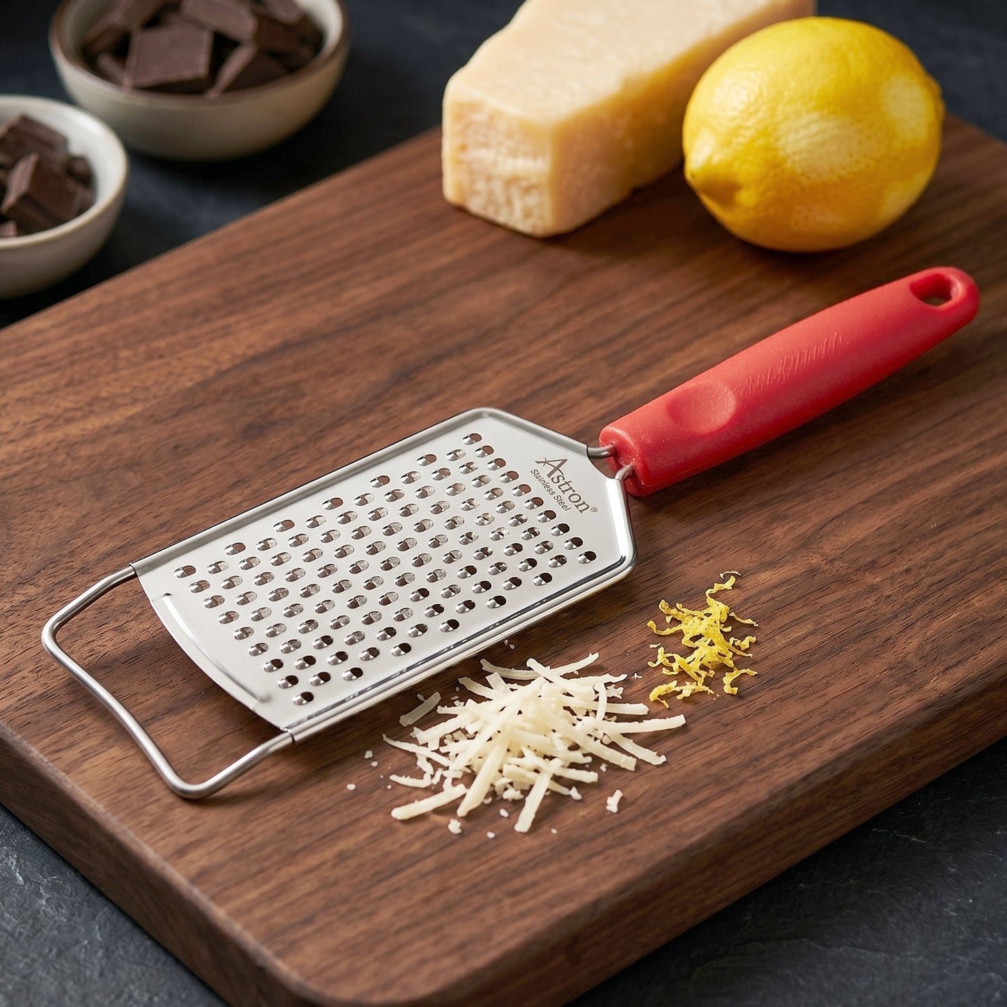 Wukusy handheld cheese grater with plastic handle, ideal for grating vegetables and lemon zest, shown in use.