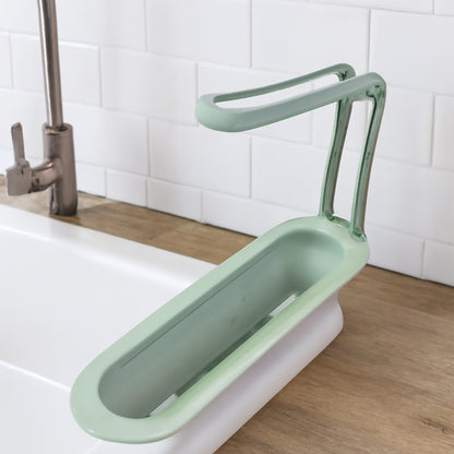 Wukusy plastic telescopic sink storage rack extending over kitchen sink, with multiple compartments for dish drying and organization.
