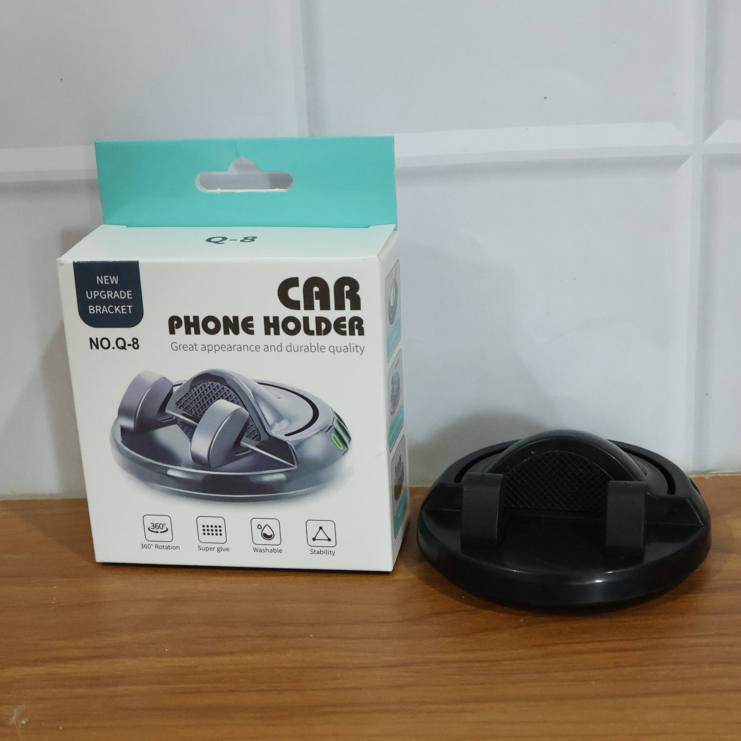 Wukusy 360° rotating anti-slip car dashboard mobile phone holder with adjustable grip, mounted on a car dashboard for secure use.