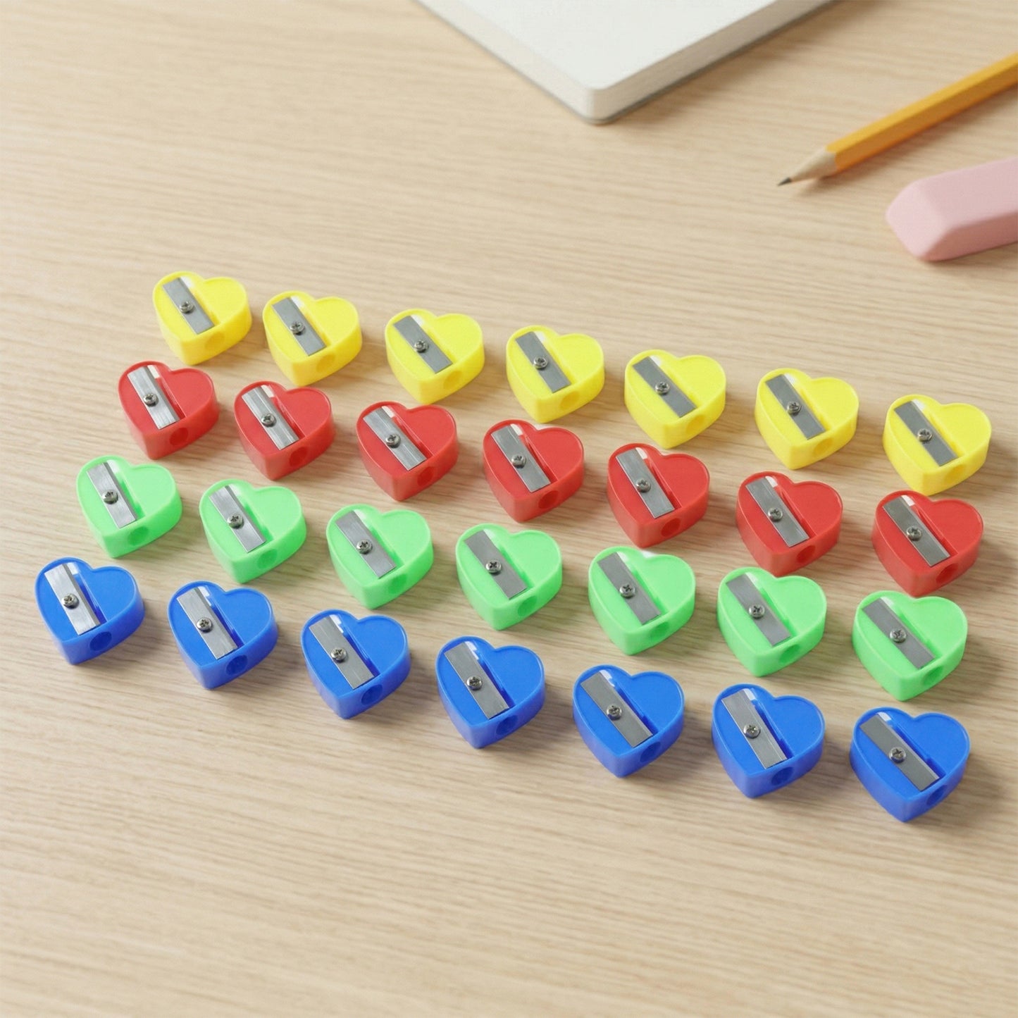 Wukusy heart-shaped pencil sharpener set with 28 colorful sharpeners arranged in a display, showcasing variety and design.