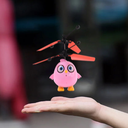 Pink owl-shaped flying bird RC toy with LED lights, remote control, and Wukusy branding, designed for kids and outdoor play.
