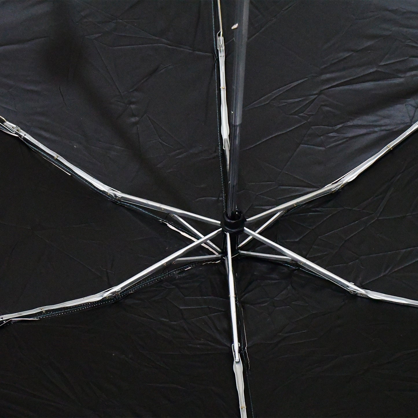 Wukusy 3-fold sun and rain protective solid foldable umbrella opened, showing its compact design and sturdy canopy for home improvement.