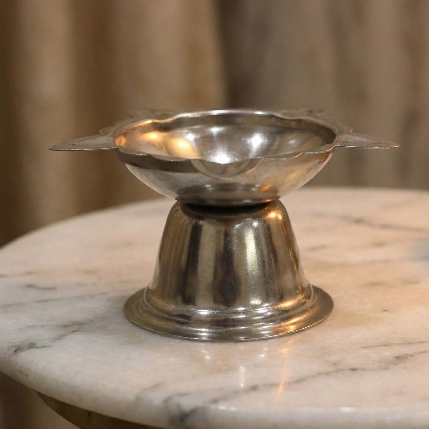 Large stainless steel sunflower design diya stand by Wukusy, featuring a detailed sunflower motif and sturdy construction.