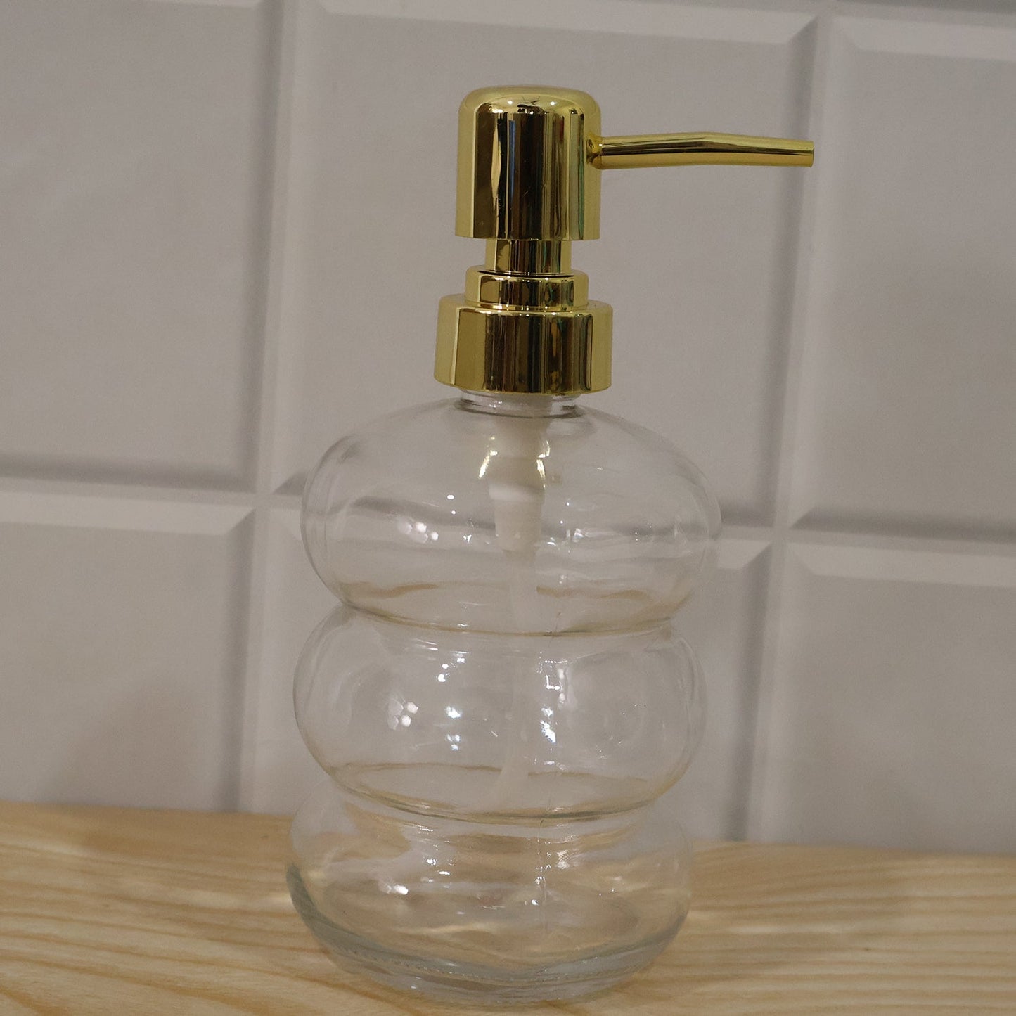 Clear glass liquid soap dispenser bottle with a gold pump by Wukusy, showcasing a sleek and elegant design.