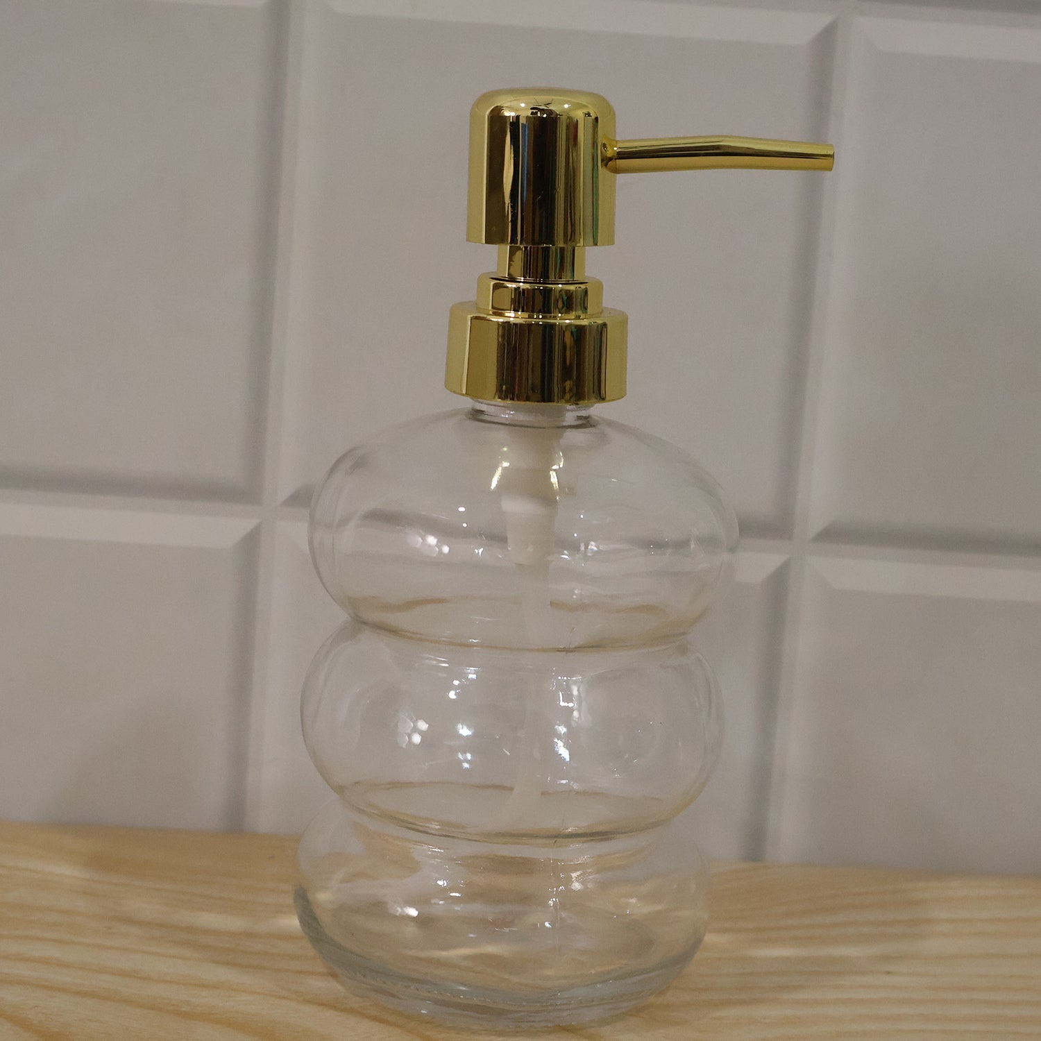 Clear glass liquid soap dispenser bottle with a gold pump by Wukusy, showcasing a sleek and elegant design.