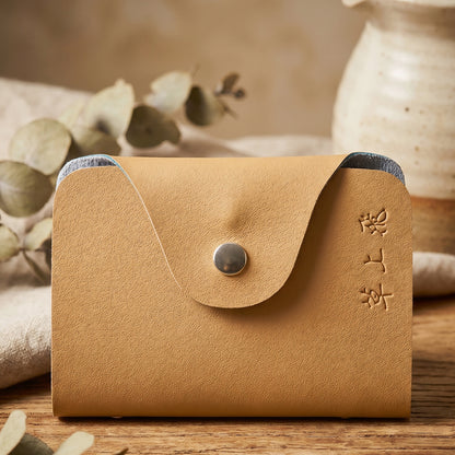 Wukusy premium leather card holder wallet with button closure and 10 inner slots, compact and stylish for carrying cards.