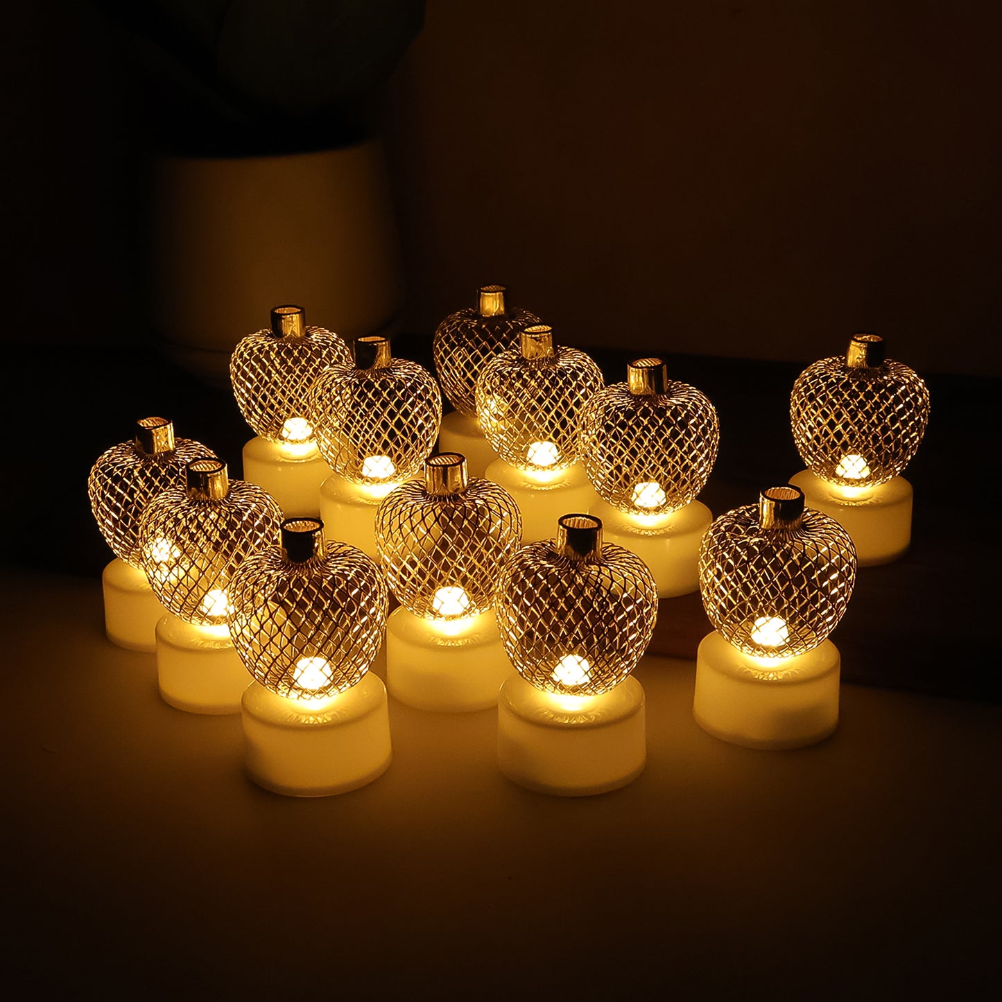 Set of 12 decorative apple-shaped LED tealight candles by Wukusy for home decor, with warm glowing light and realistic apple design.