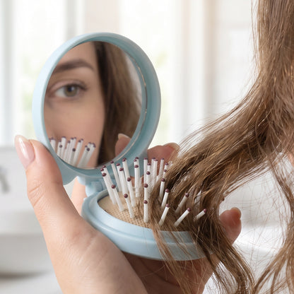 Wukusy 2-in-1 folding hair brush with mirror, compact pop-up design for travel grooming, showing the brush and mirror in a closed position.