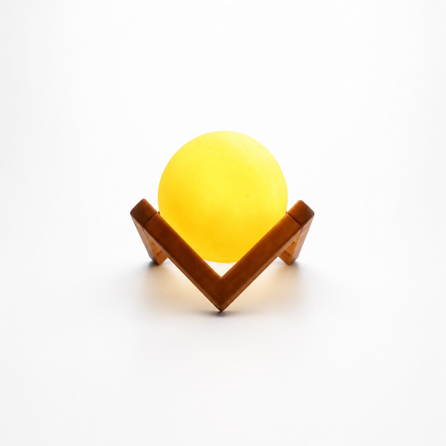 Wukusy LED ball night lamp with wooden stand, illuminated and glowing softly on a dark background.