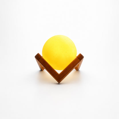 Wukusy LED ball night lamp with wooden stand, illuminated and glowing softly on a dark background.