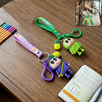 Cute cartoon doll keychain with pineapple charm and strap, featuring Wukusy brand, hanging from a keyring.