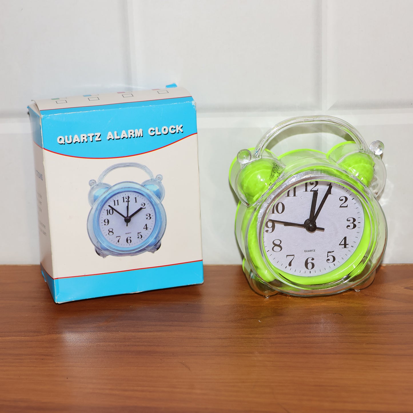 Wukusy Classic Quartz Alarm Clock showing round face with black numbers and silver frame on a wooden surface.