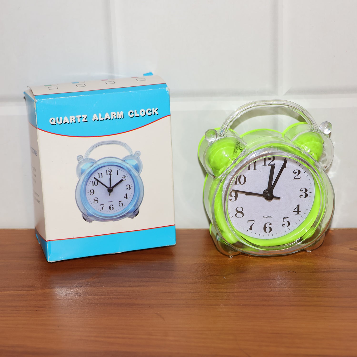 Wukusy Classic Quartz Alarm Clock showing round face with black numbers and silver frame on a wooden surface.
