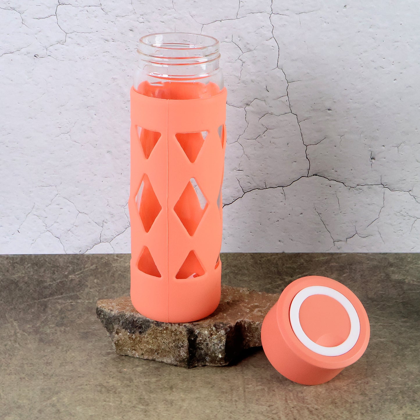 Wukusy glass water bottle with protective sleeve, 480ml capacity, in a home and kitchen setting, showing the durable protective cover.