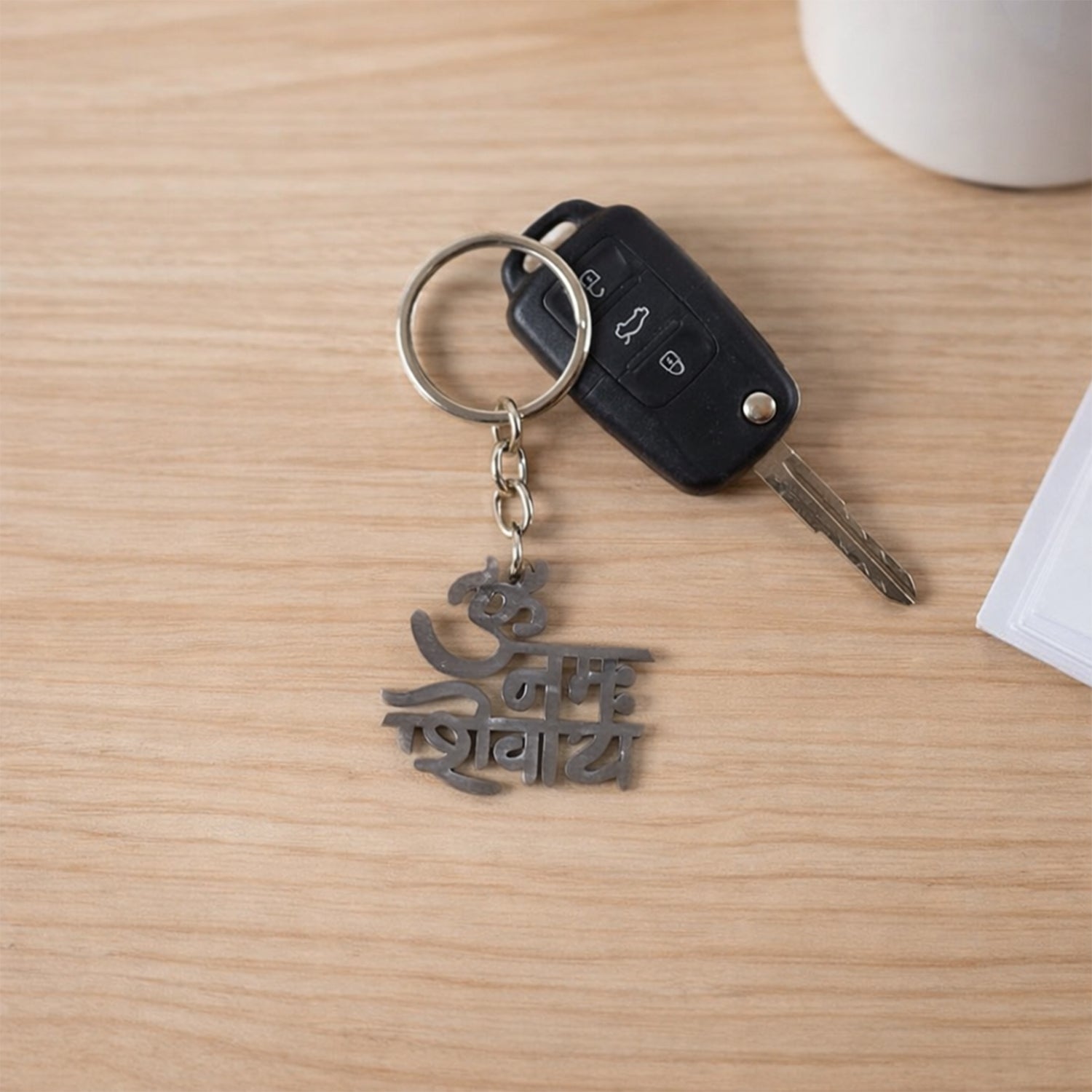 Wukusy metal keychain engraved with Om Namah Shivay symbol, featuring intricate design and polished finish.