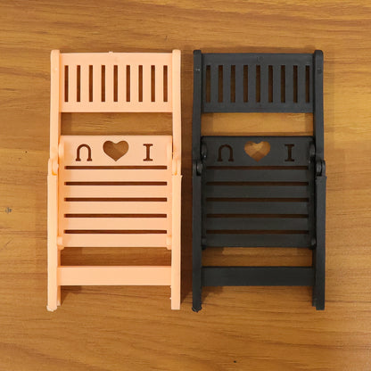 Wukusy mini chair-shaped mobile stand holder for smartphones, compact and decorative, shown in black on a white background.