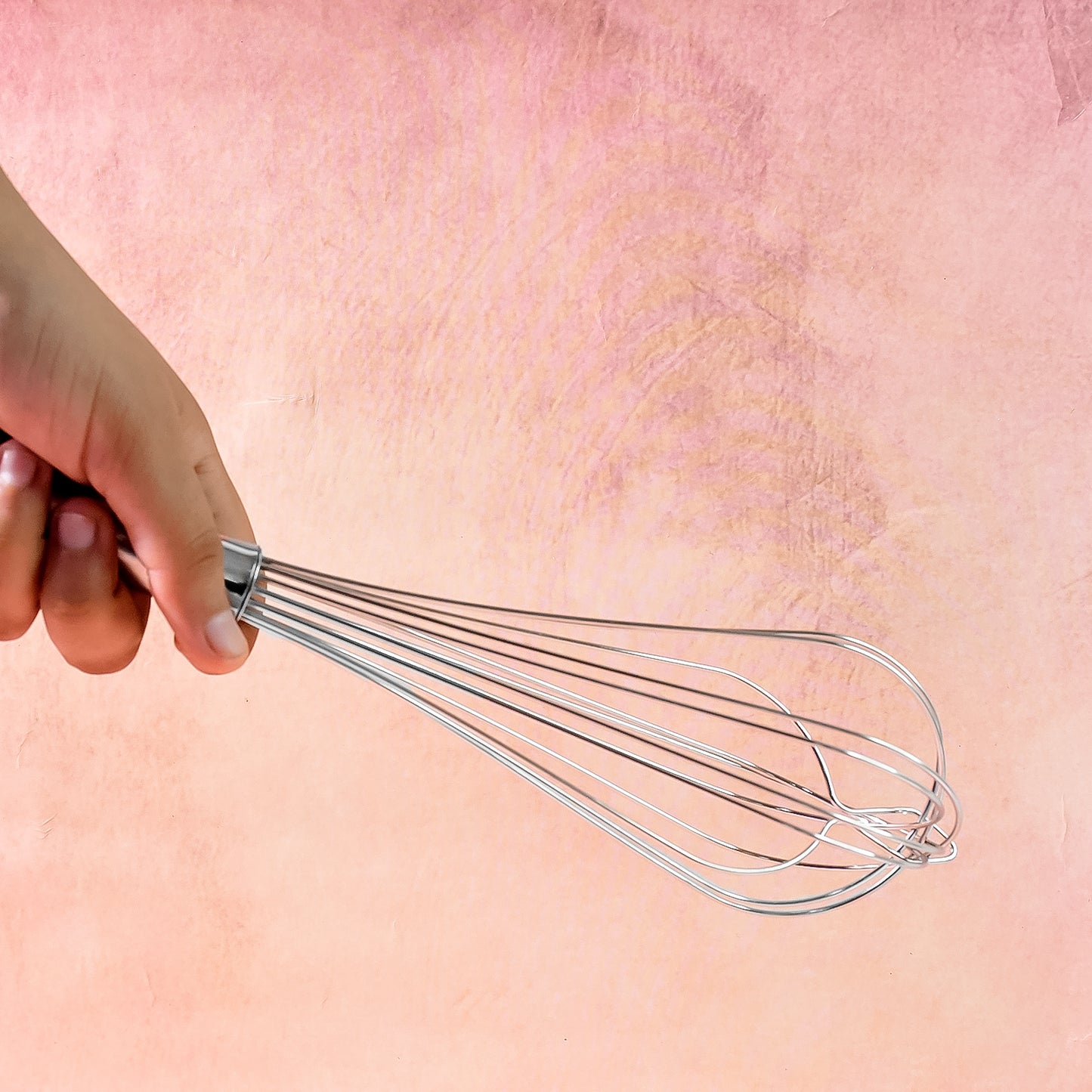 Wukusy Apex stainless steel medium hand whisk for kitchen mixing, with a sturdy handle and multiple wire loops for whipping and blending.