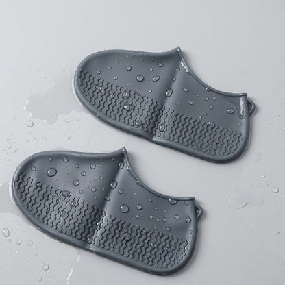 Pair of Wukusy waterproof silicone shoe covers in grey, medium size, designed to protect shoes from water and dirt.