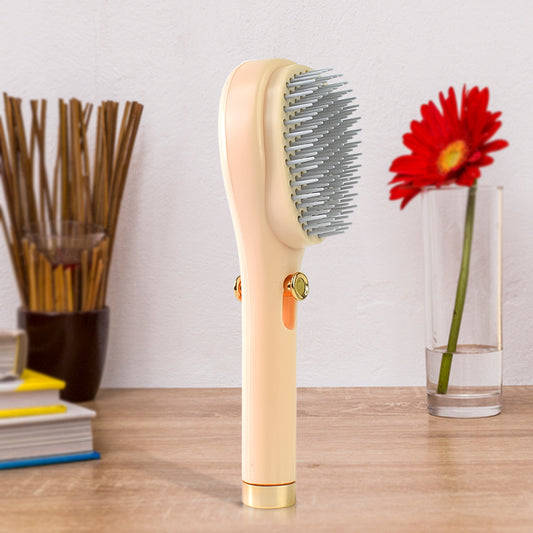 Wukusy self-cleaning anti-static massage comb with ergonomic handle and flexible teeth for gentle scalp care and detangling.