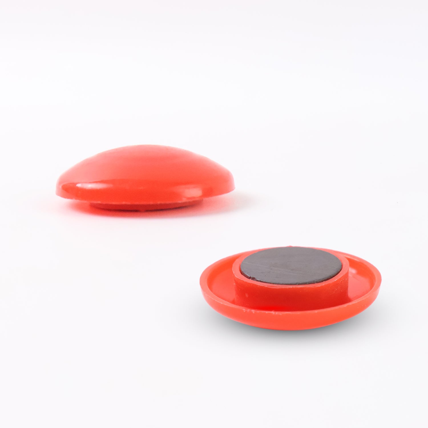 Red circular plastic magnet with Wukusy branding, featuring a smooth surface and embedded magnetic backing.