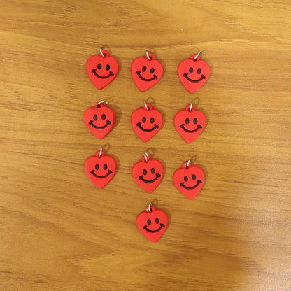 Set of 10 Wukusy cute smiley heart-shaped bag charm keychains in vibrant colors, perfect for decorating bags and keys.