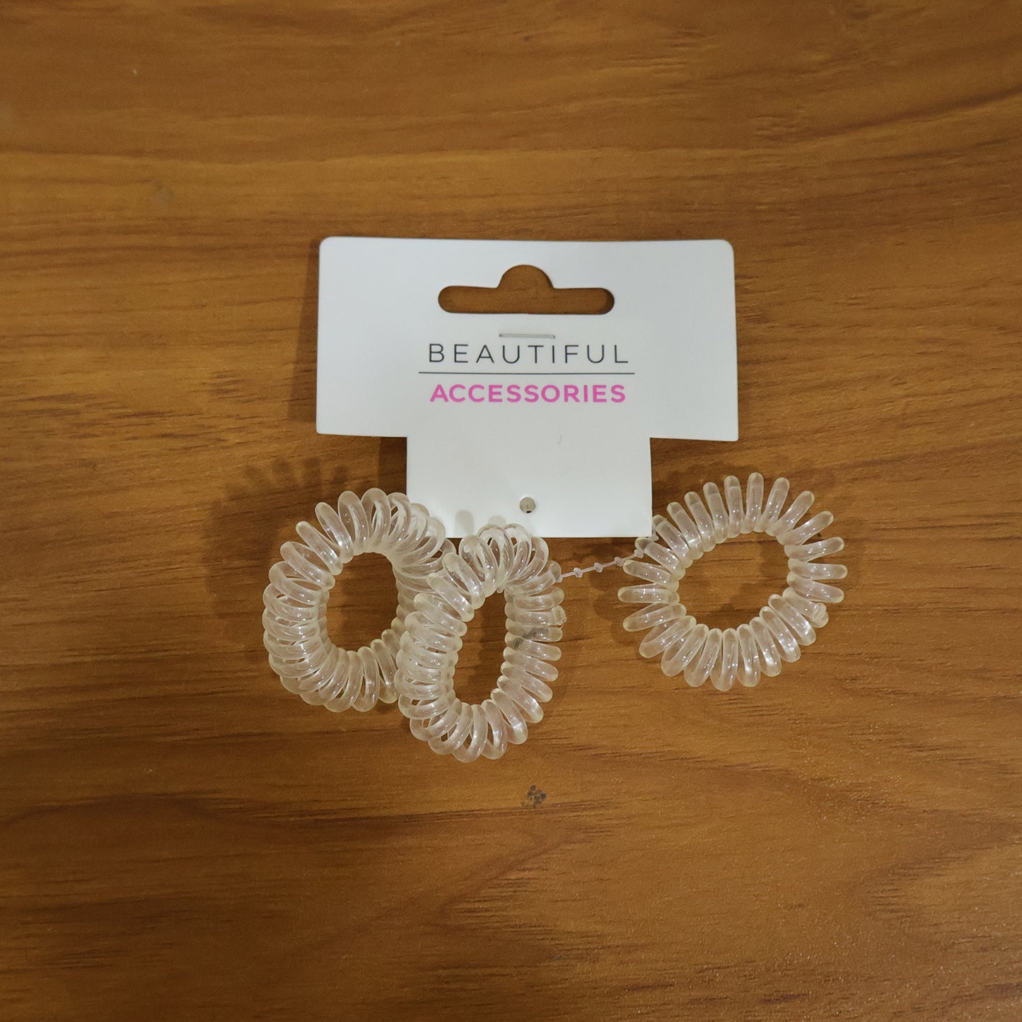 Set of three transparent spiral coil hair bands with matching cases by Wukusy, ideal for secure and stylish hair styling.