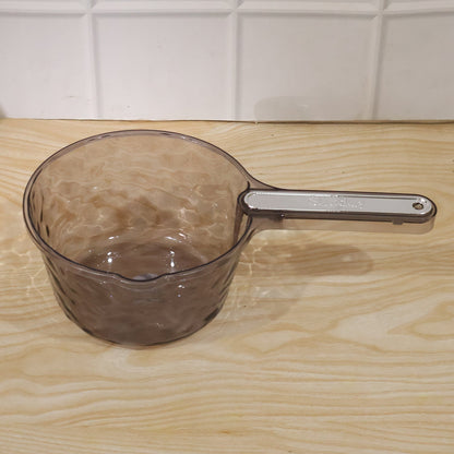 Wukusy transparent plastic water dipper scoop with handle, designed for bathroom use, shown with water inside the scoop.