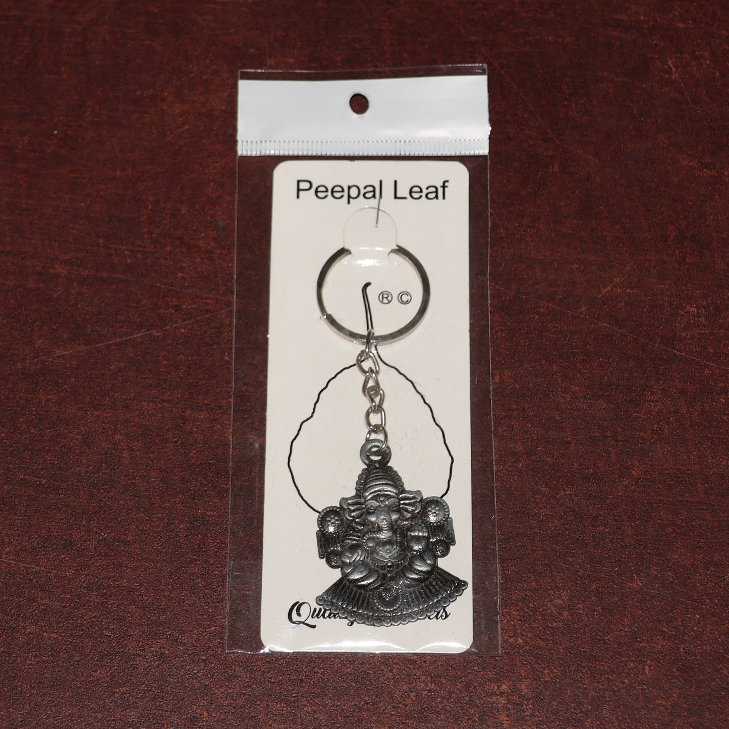 Silver Lord Ganesha sitting design keychain by Wukusy, featuring detailed Ganesha figure on a sleek keychain.
