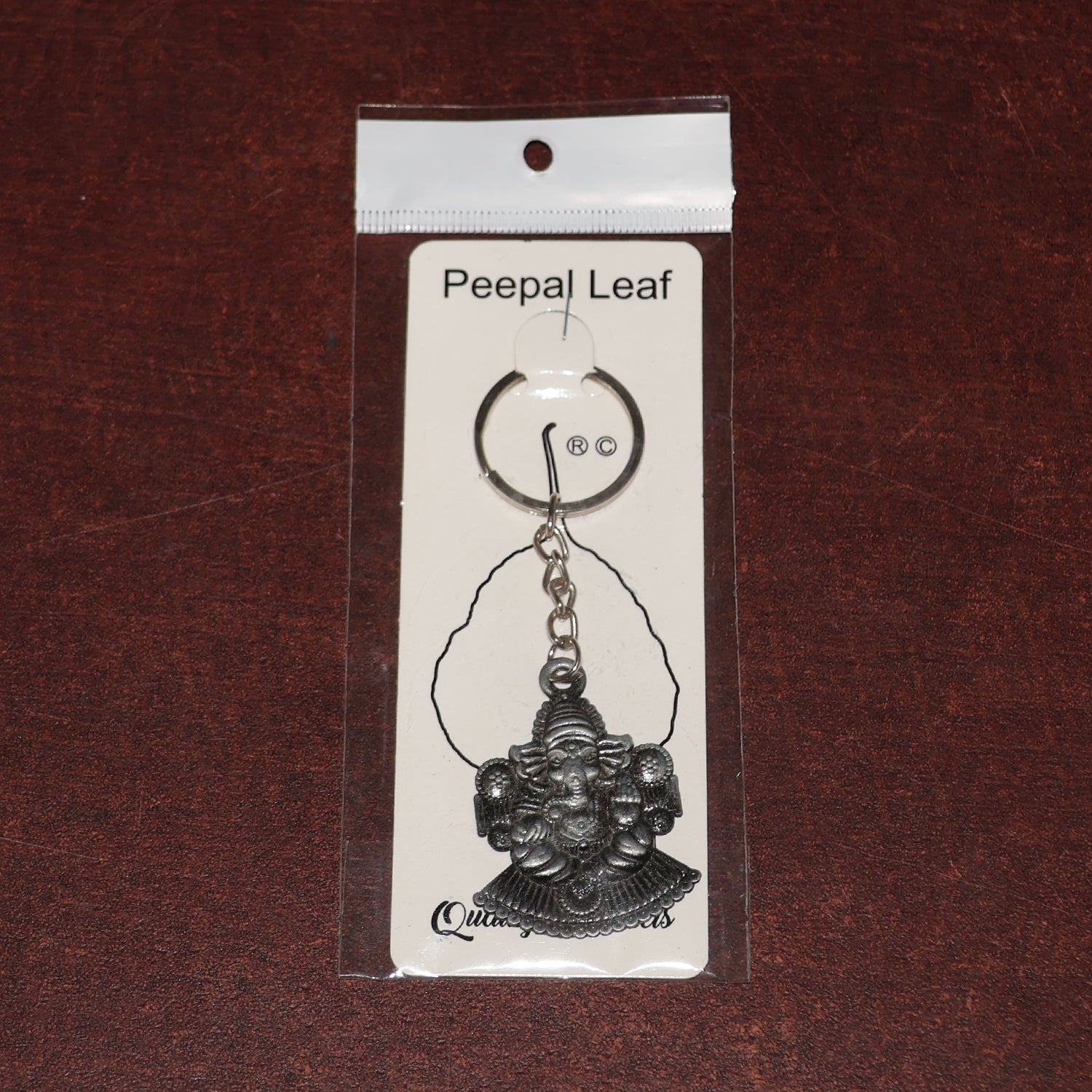 Silver Lord Ganesha sitting design keychain by Wukusy, featuring detailed Ganesha figure on a sleek keychain.