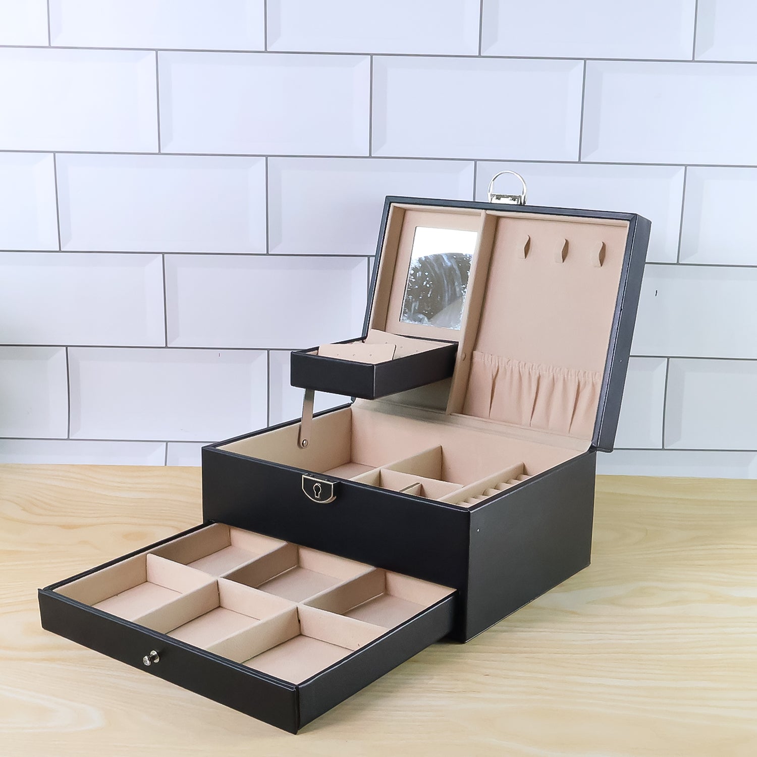 Wukusy multi-layer jewelry organizer box with compartments for rings, necklaces, and earrings, made of black faux leather.