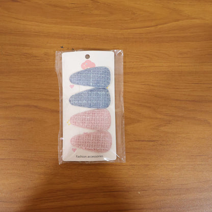Set of four Wukusy textured fabric snap hair clips showing colorful, patterned designs on a neutral background.
