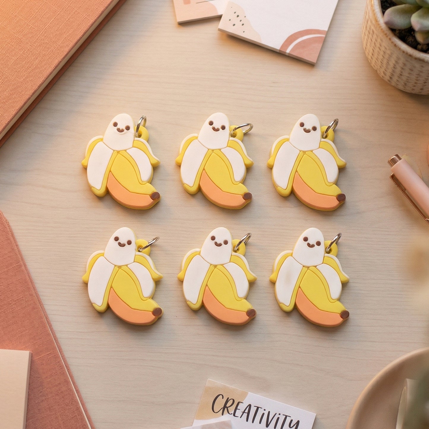 Set of 10 cute cartoon banana bag charm keychains by Wukusy featuring playful yellow banana designs and vibrant accessories.