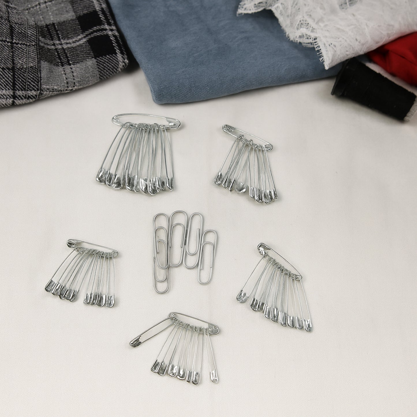 Assorted metal safety pins from Wukusy, including various sizes for sewing, craft projects, and securing fabrics or materials.