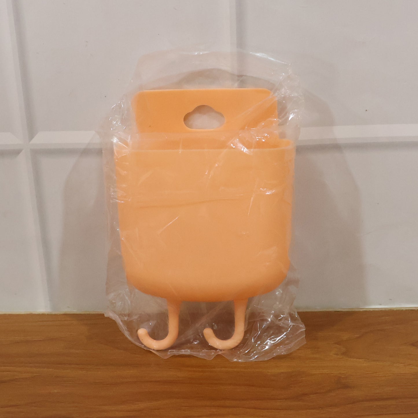 Wall-mounted plastic mobile charging holder by Wukusy, featuring multiple slots for organizing and charging smartphones.