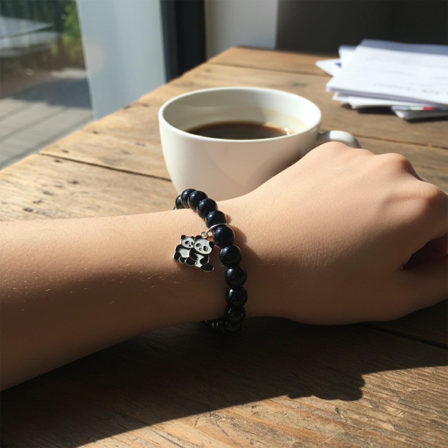 Black beaded stretch bracelet by Wukusy with a cute panda charm, featuring elastic design and stylish accessory for casual wear