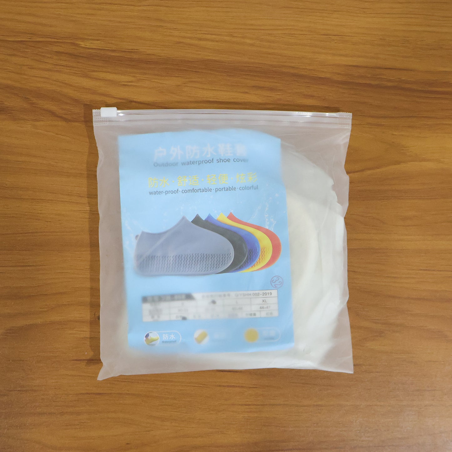 Pair of white waterproof silicone shoe covers by Wukusy, medium size, protecting shoes from water and dirt.