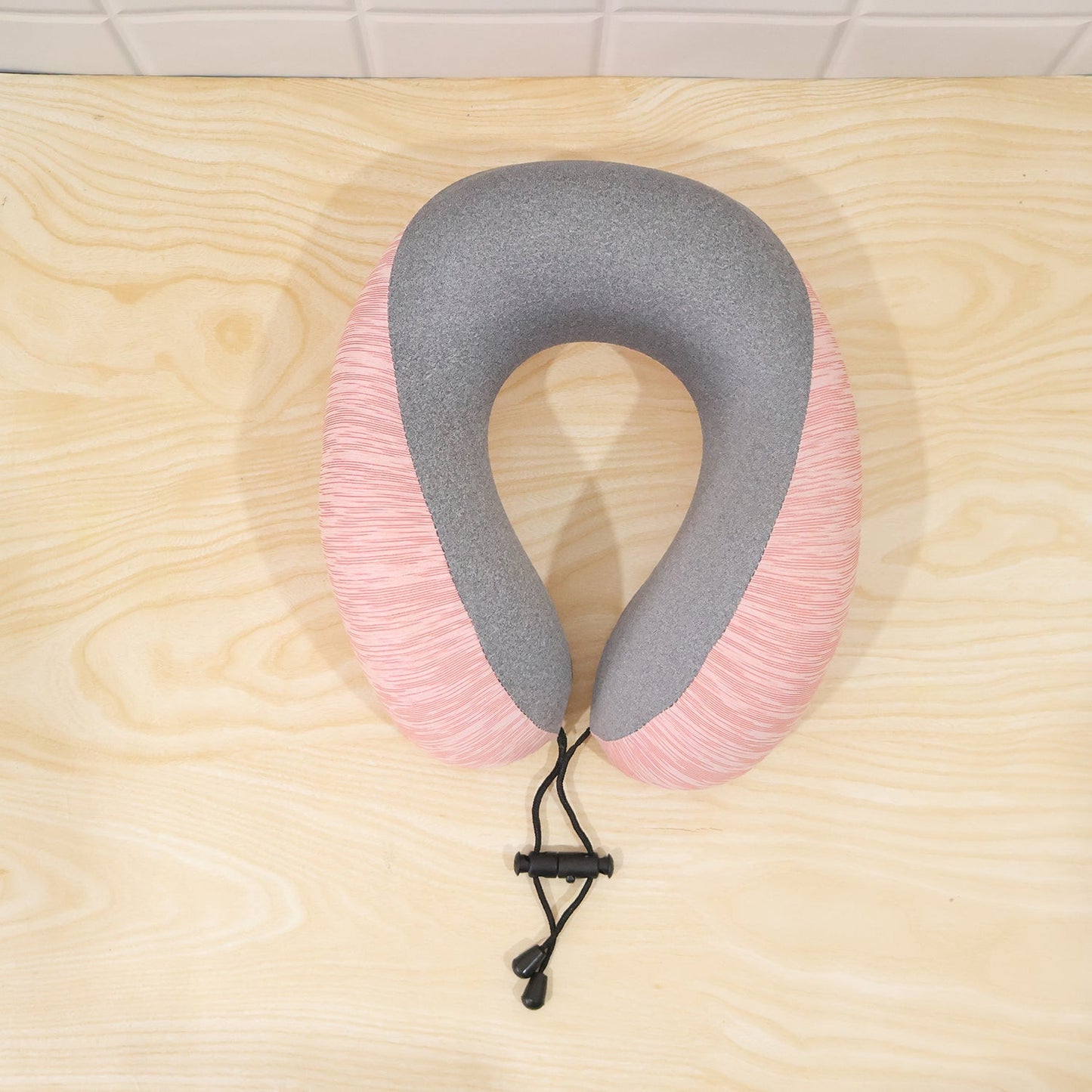 Pink and grey U-shaped travel neck pillow with drawstring toggle from Wukusy, designed for comfortable support during travel.