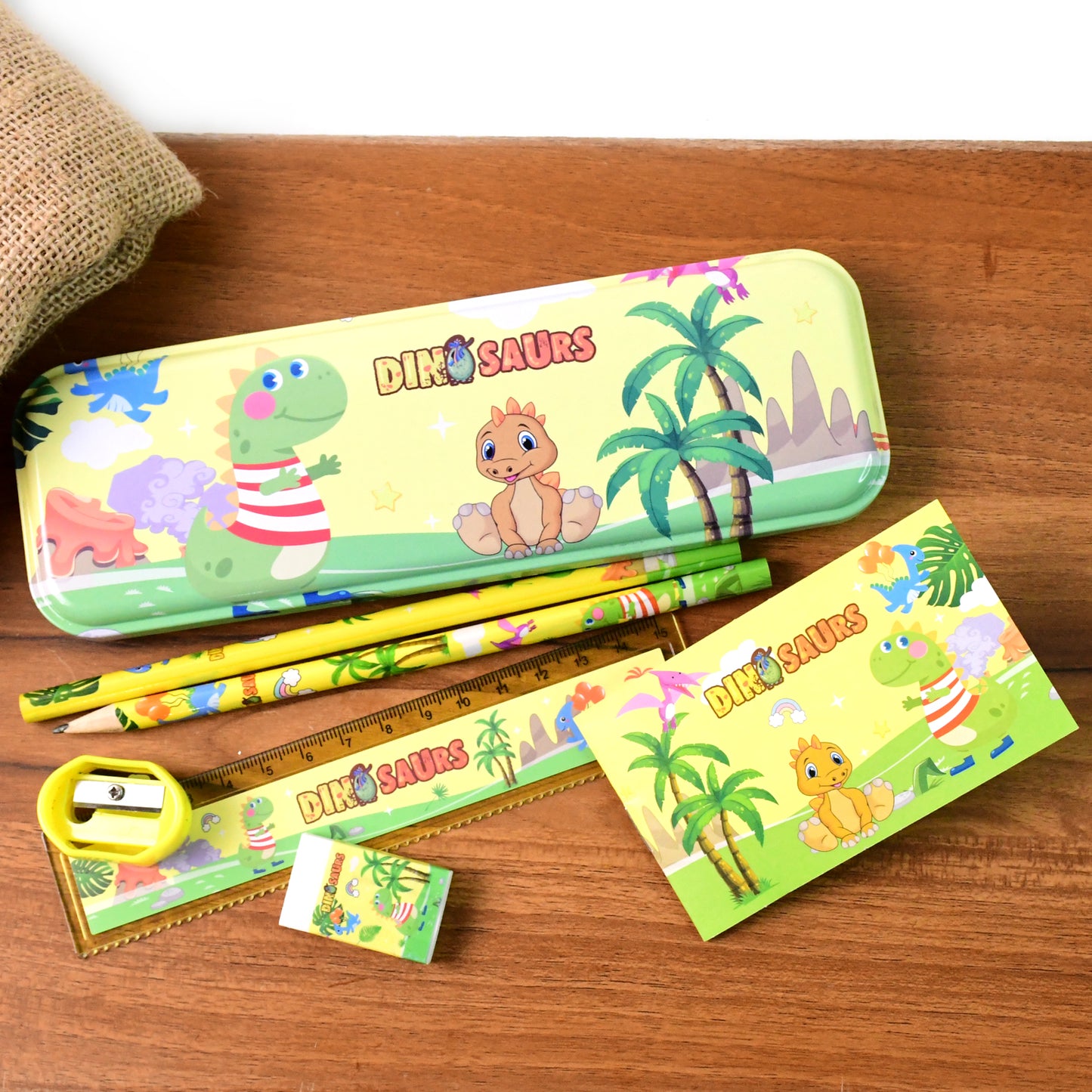 Colorful dinosaur printed kids stationery set by Wukusy, including notebooks, pens, and stickers featuring fun dinosaur designs.