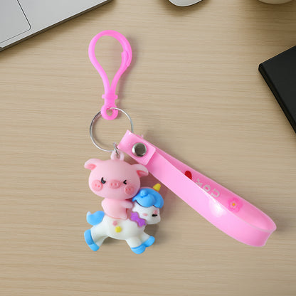 Cute Wukusy pig riding a colorful cartoon unicorn keychain, detailed plastic charm with vibrant colors and whimsical design.