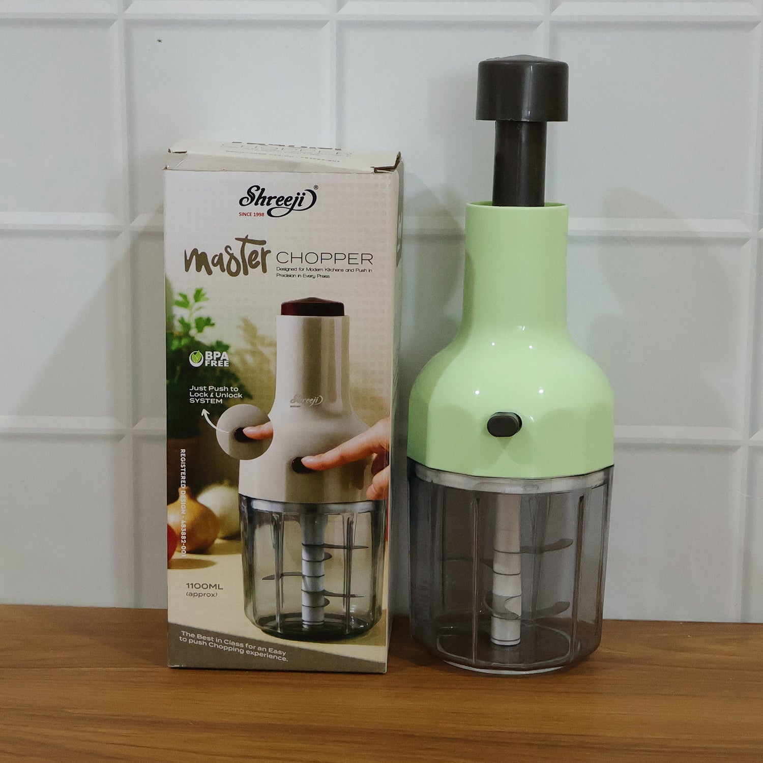 Wukusy manual push vegetable chopper with 1100 ml capacity, featuring stainless steel blades and a clear plastic container.