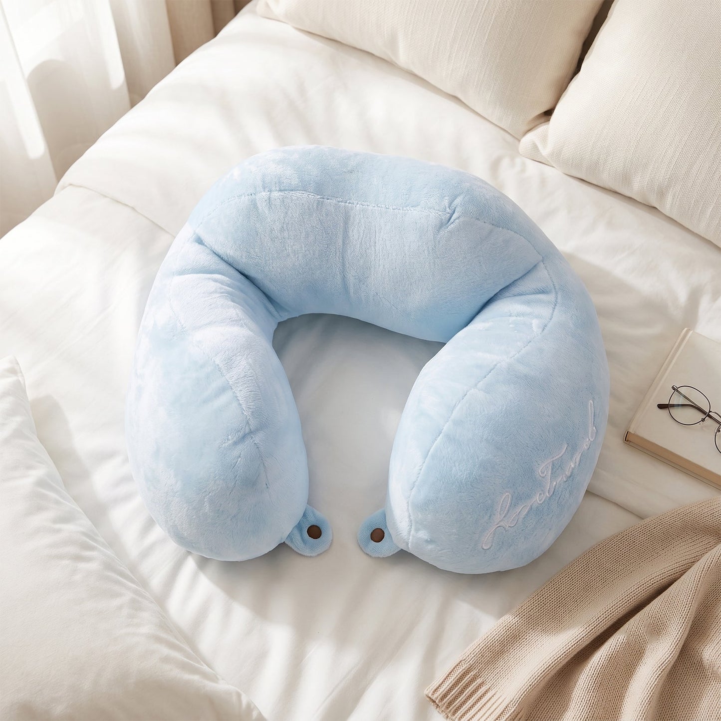 Blue Wukusy U-shaped travel neck pillow with plush fabric, providing head and neck support for comfortable journeys.